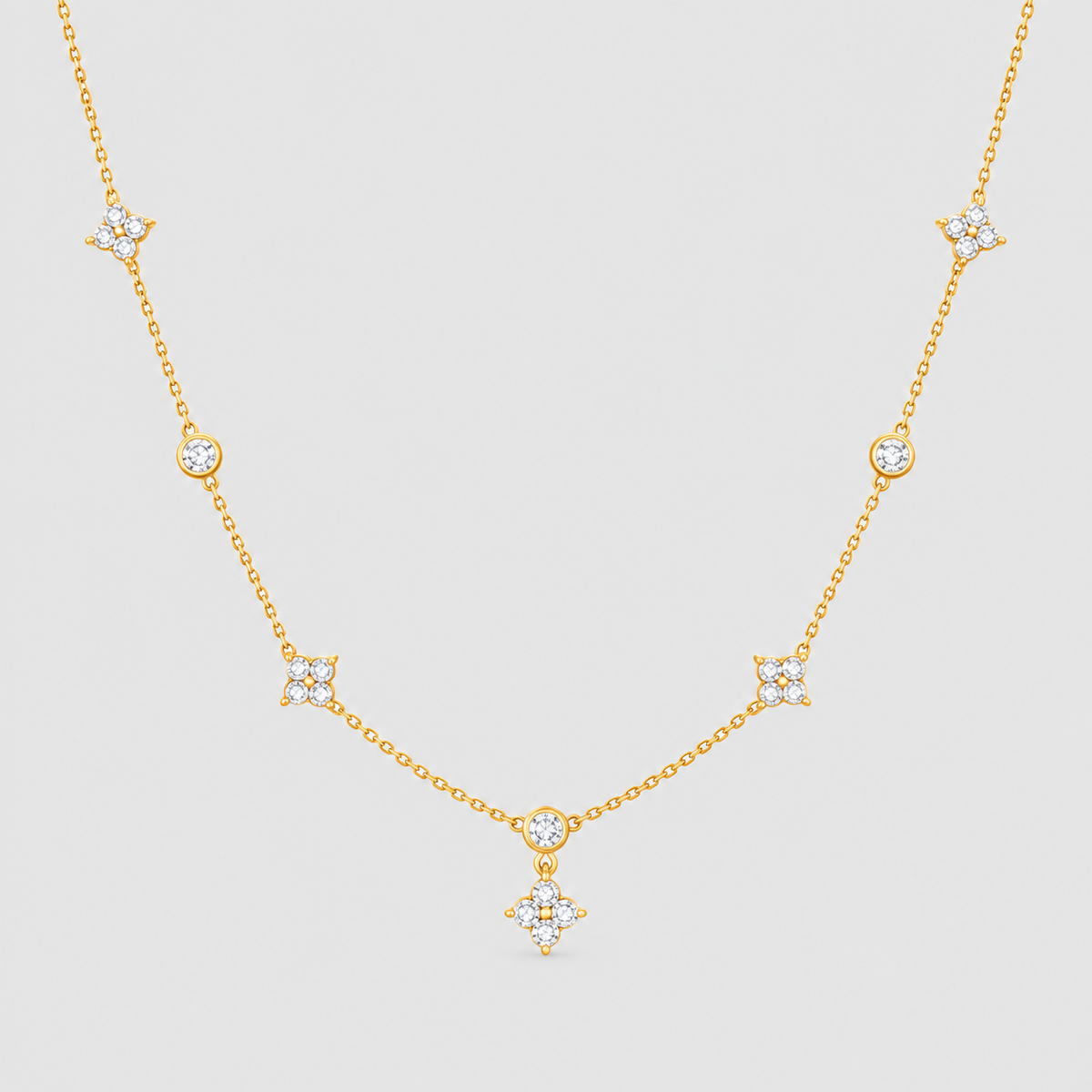 A delicate gold chain necklace featuring multiple small star and crescent moon motifs set with clear stones, displayed against a solid light gray background.