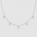 A delicate silver-toned chain necklace featuring five small, bezel-set round clear gemstones spaced along the chain, displayed against a light gray background.