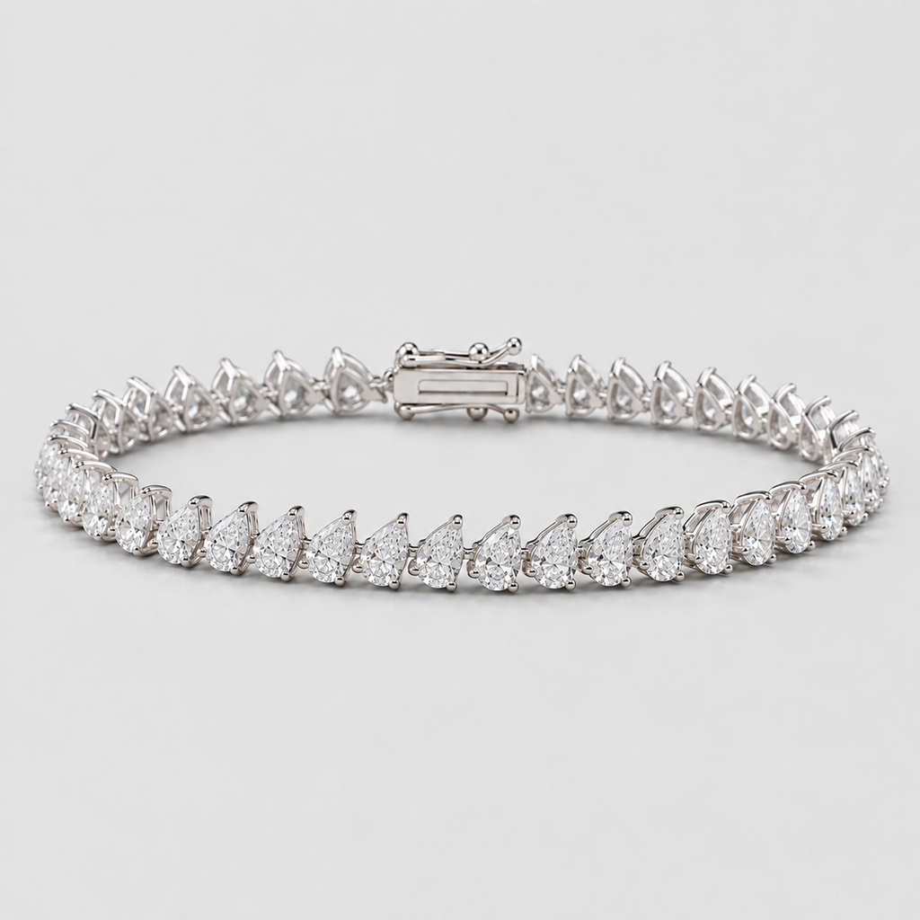 A diamond tennis bracelet featuring pear-cut and round diamonds set in a silver-colored metal, shown on a light gray background.