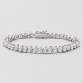 A diamond tennis bracelet featuring pear-cut and round diamonds set in a silver-colored metal, shown on a light gray background.