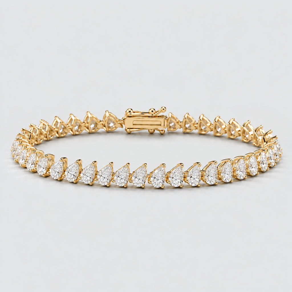 A yellow gold tennis bracelet featuring rows of pear-cut diamonds, displayed on a clean light gray background.