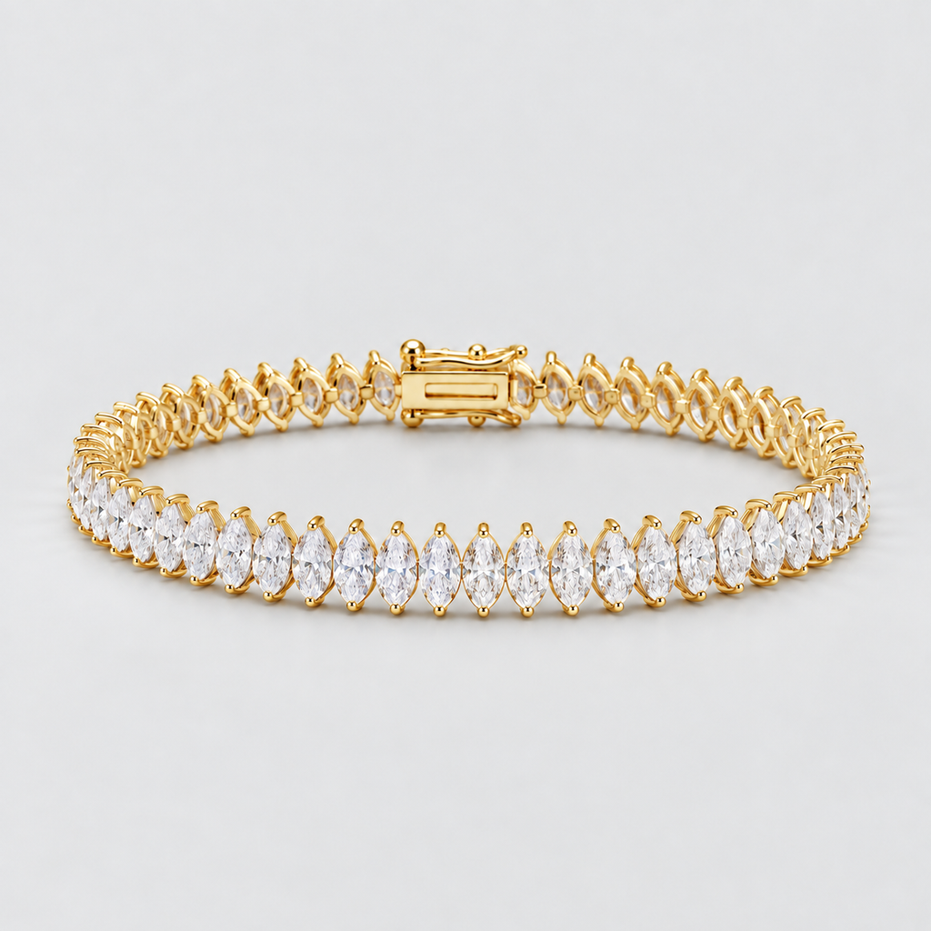A yellow gold tennis bracelet featuring a row of marquise-cut clear gemstones, displayed on a light gray background.