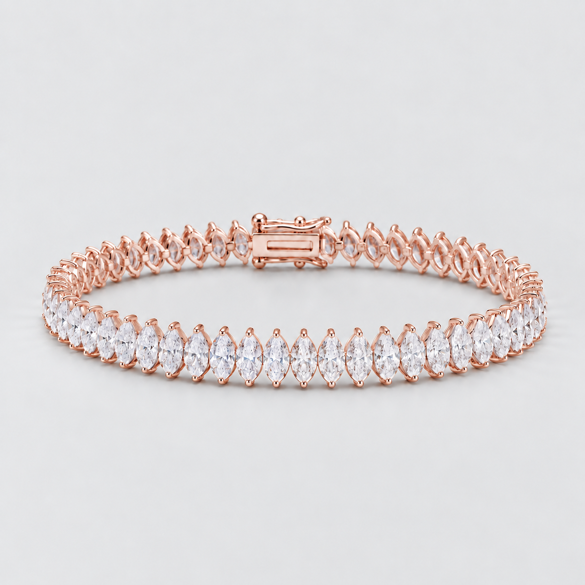 A rose gold tennis bracelet featuring a row of marquise-cut clear gemstones, displayed on a clean light gray background.