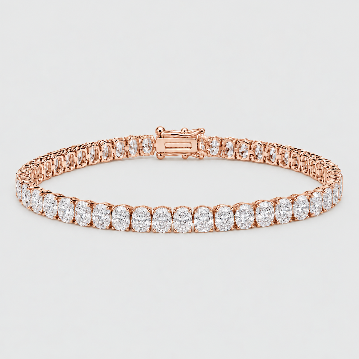 A rose gold tennis bracelet featuring a row of round-cut clear gemstones, displayed on a light gray background.