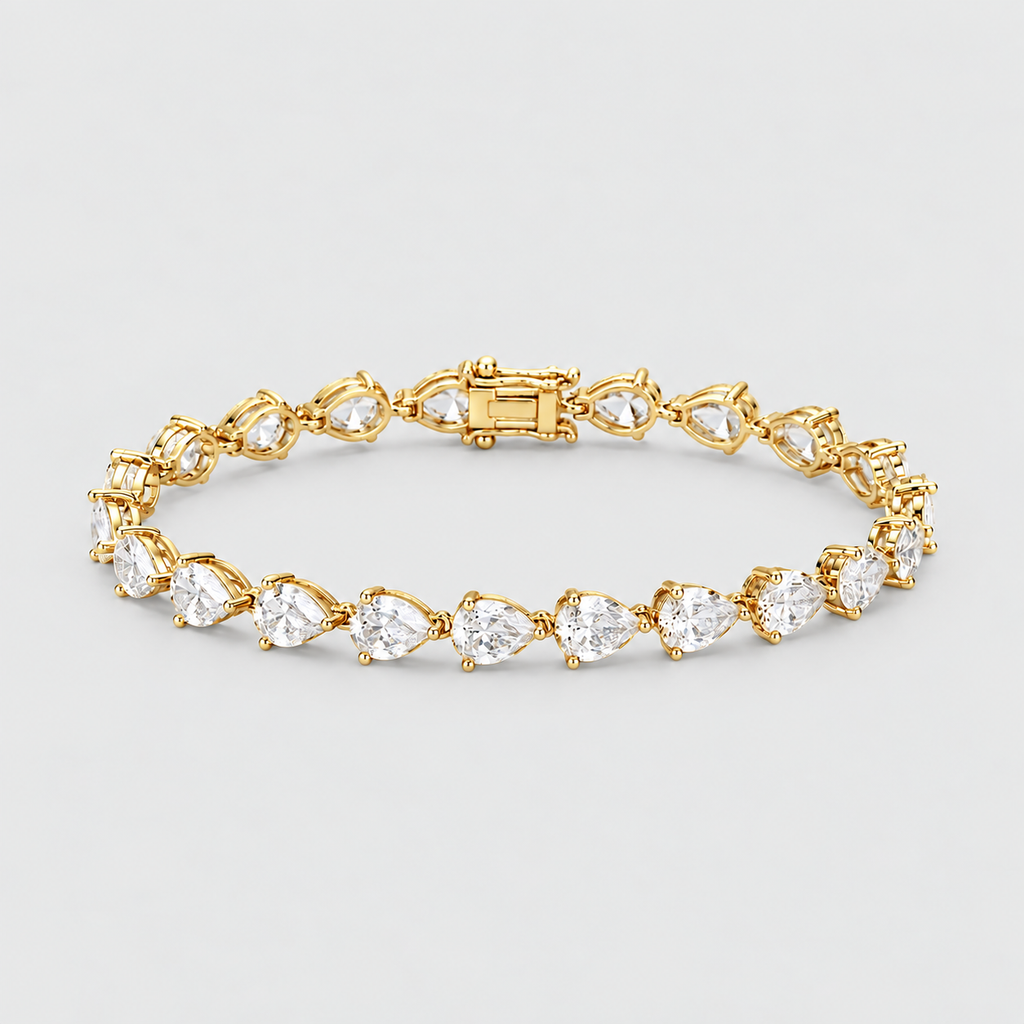 A yellow gold tennis bracelet featuring a continuous row of pear-cut clear gemstones in a prong setting, displayed on a light gray background.