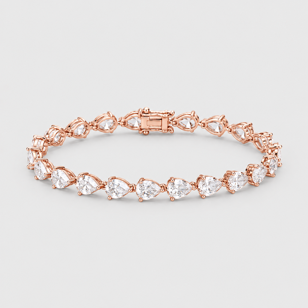 A rose gold tennis bracelet featuring a series of pear-cut clear gemstones in a classic four-prong setting, displayed on a neutral light gray background.