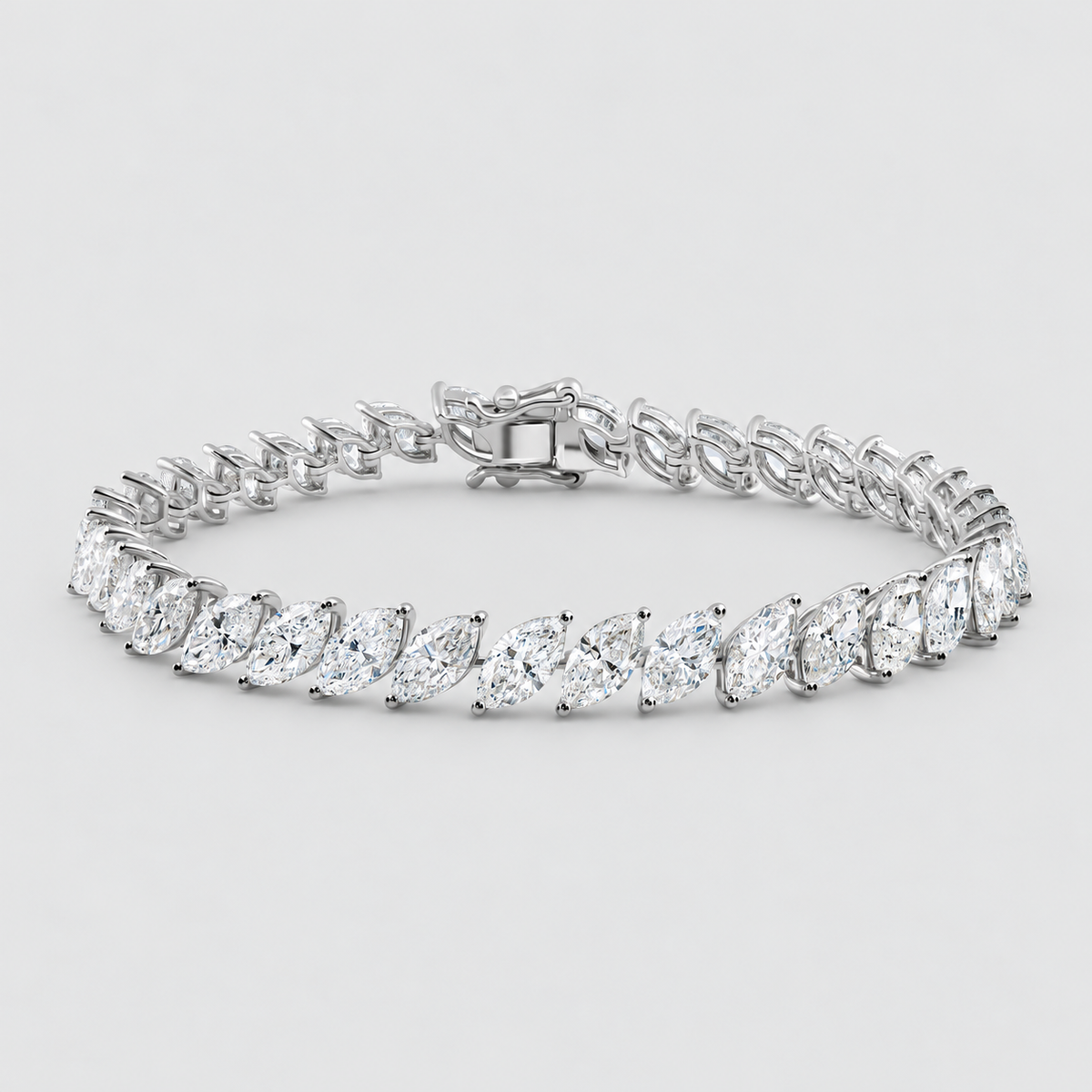 A silver tennis bracelet featuring marquise-cut clear gemstones in a continuous row, displayed on a clean light gray background.