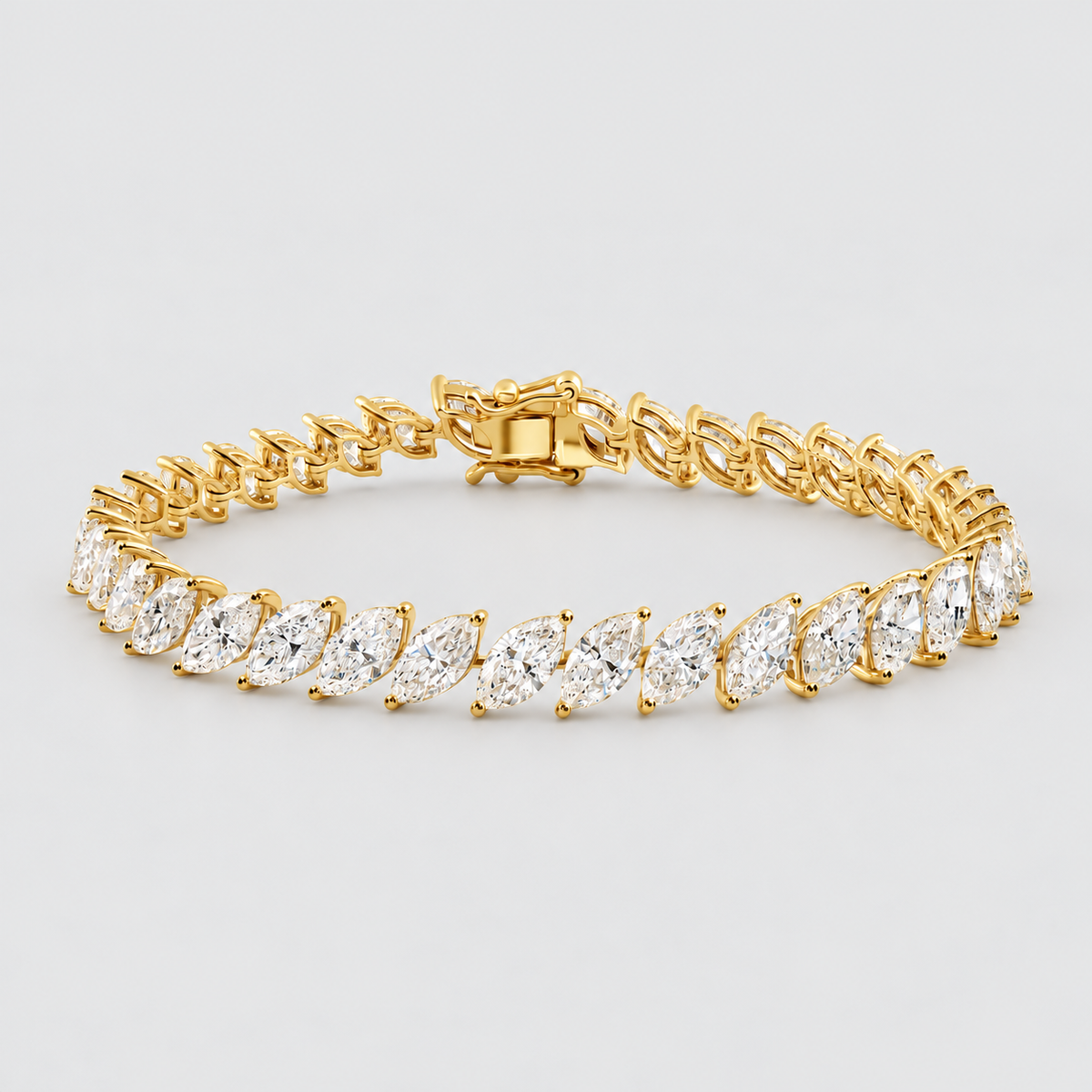 A yellow gold tennis bracelet featuring marquise-cut clear gemstones in a classic solitaire setting, displayed on a clean light gray background.