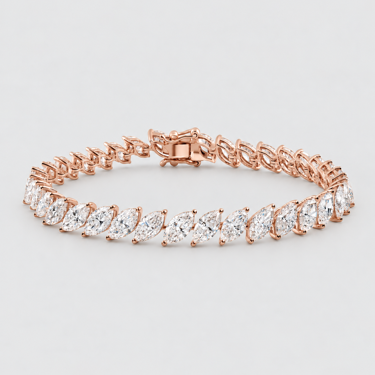 A rose gold tennis bracelet featuring marquise-cut clear gemstones, displayed on a clean light gray background.