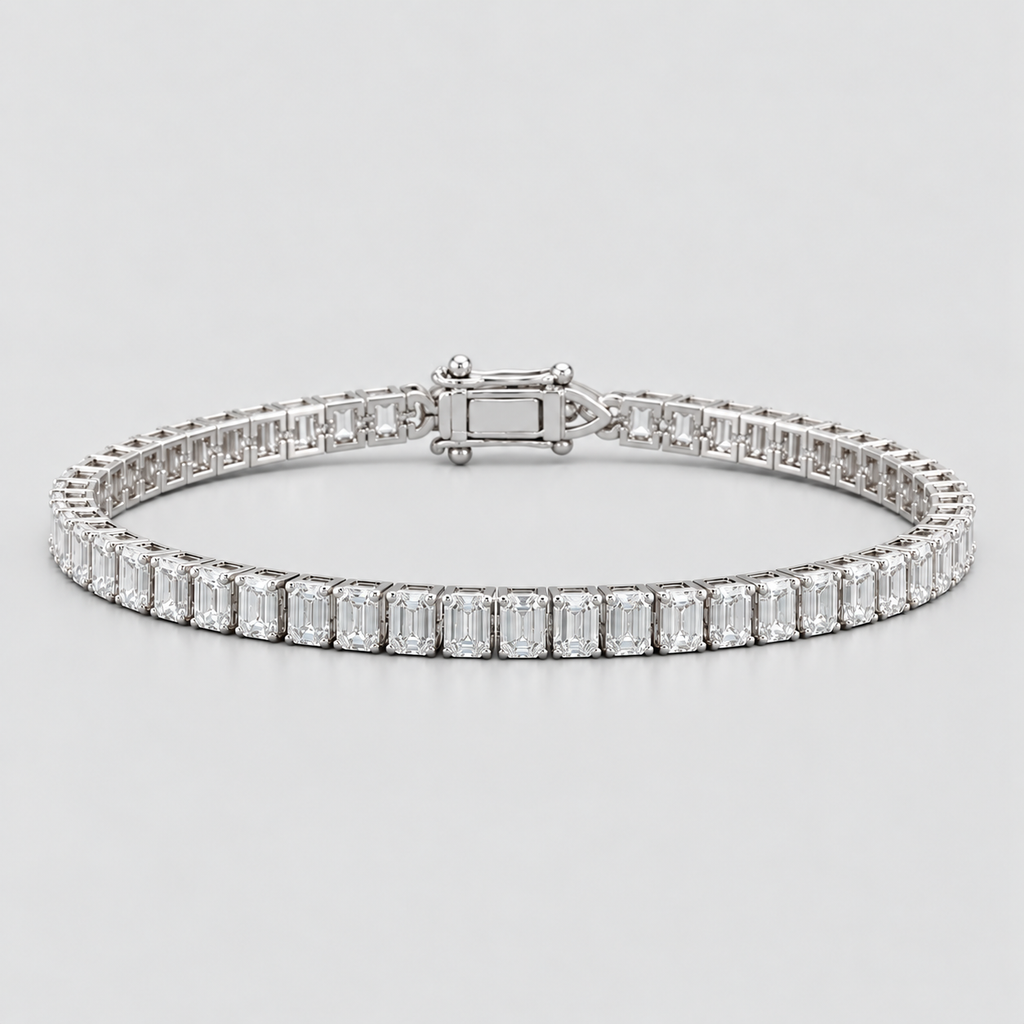 A silver tennis bracelet featuring a continuous row of baguette-cut clear gemstones in a polished silver setting, displayed on a light gray background.