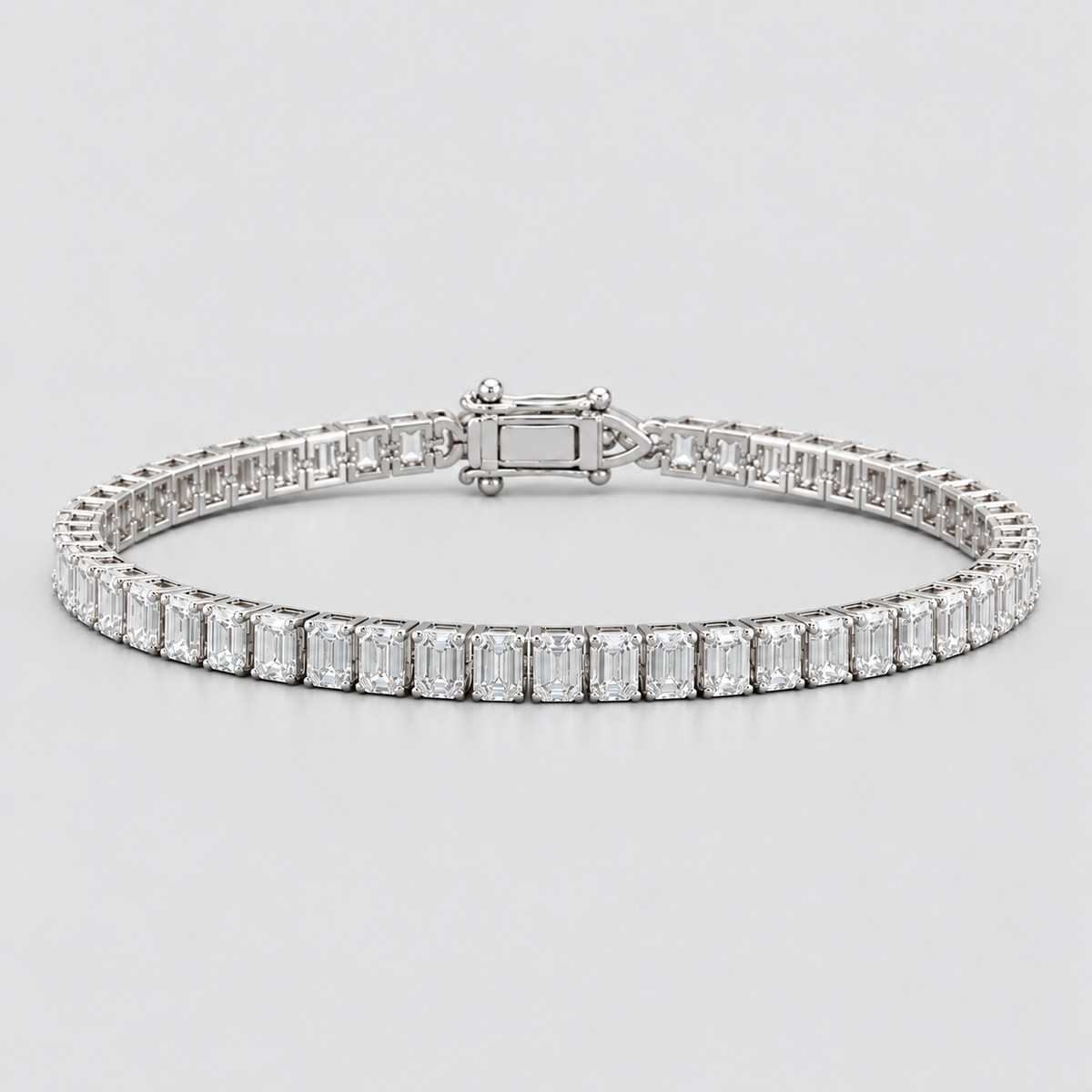 A silver tennis bracelet featuring a continuous row of baguette-cut clear gemstones in a polished silver setting, displayed on a light gray background.
