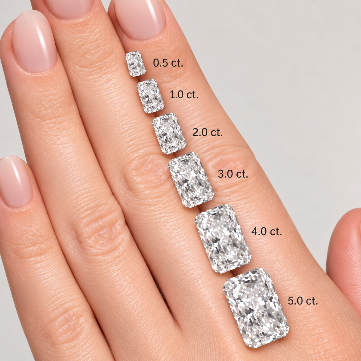 A close-up of a hand displaying five rectangular radiant-cut gemstones in increasing carat sizes, labeled 0.5 ct.